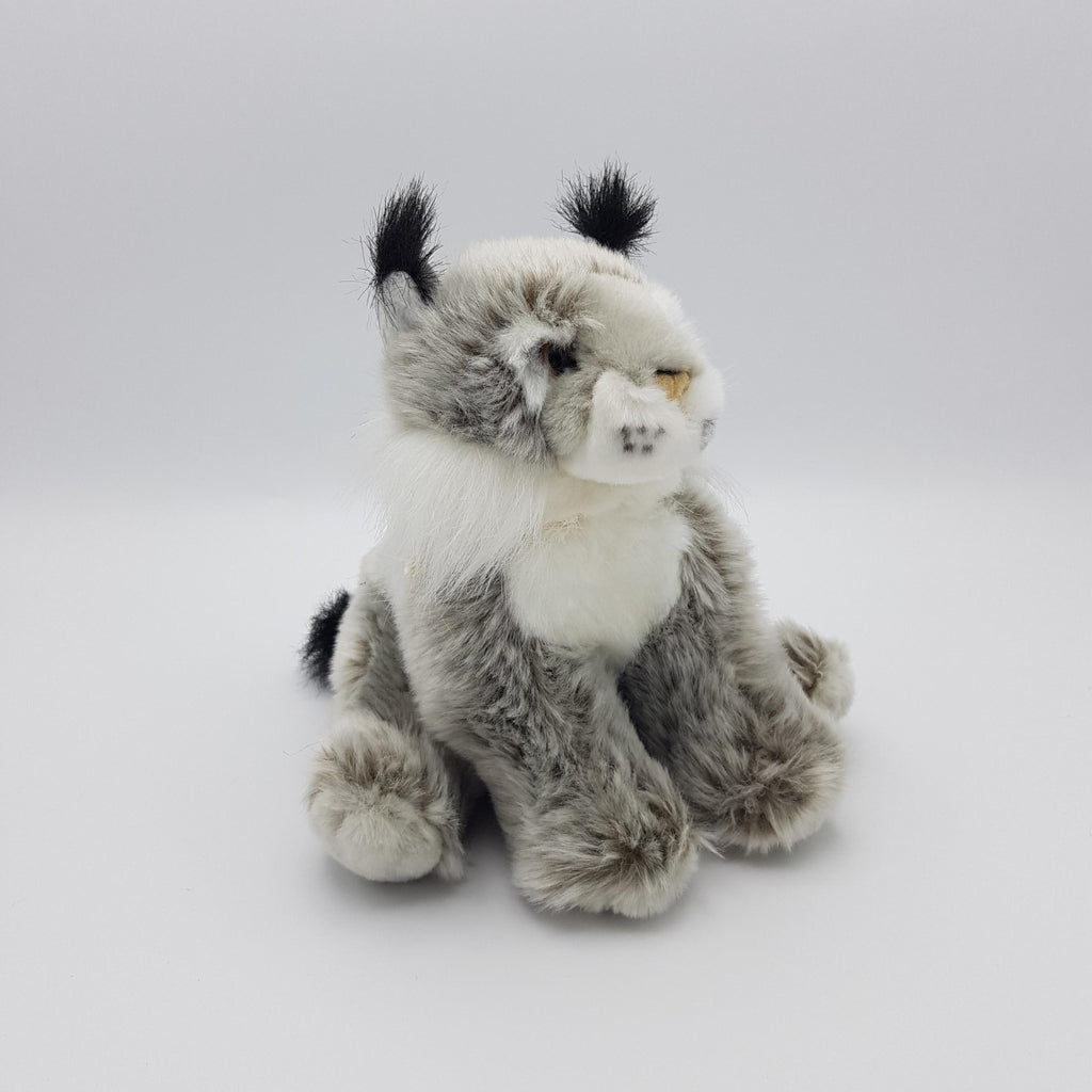 A fluffy grey lynx soft toy sitting upright