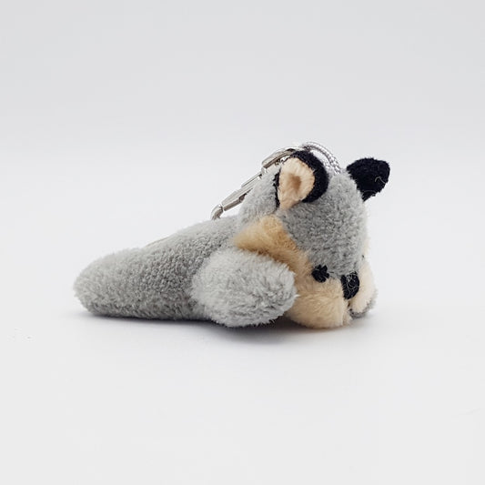 A small grey wolf plush keyring