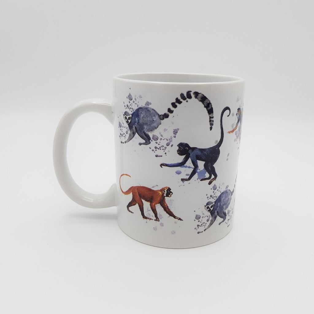 A white ceramic mug featuring watercolour designs of  grey ring-tailed lemurs and small monkeys.