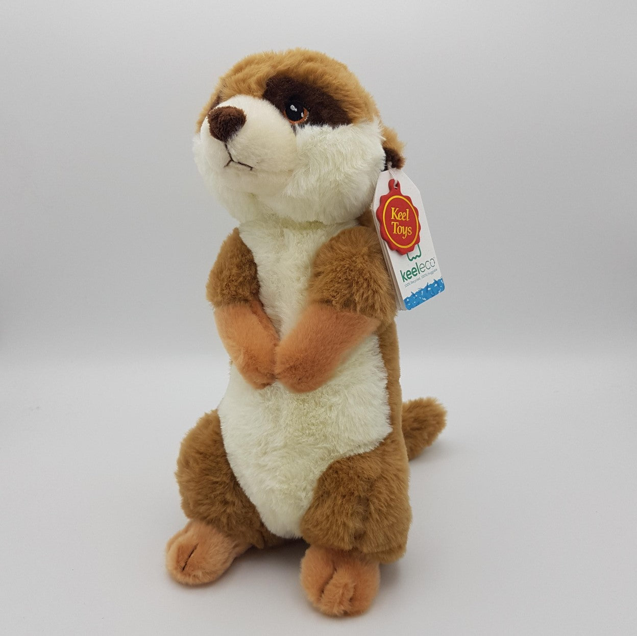 The side profile of a meerkat eco soft toy, with a white belly, brown eyes and tanned back, sat upright