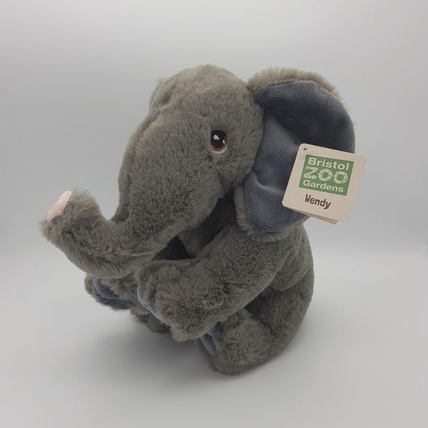 Plush grey elephant toy with tag, sitting upright