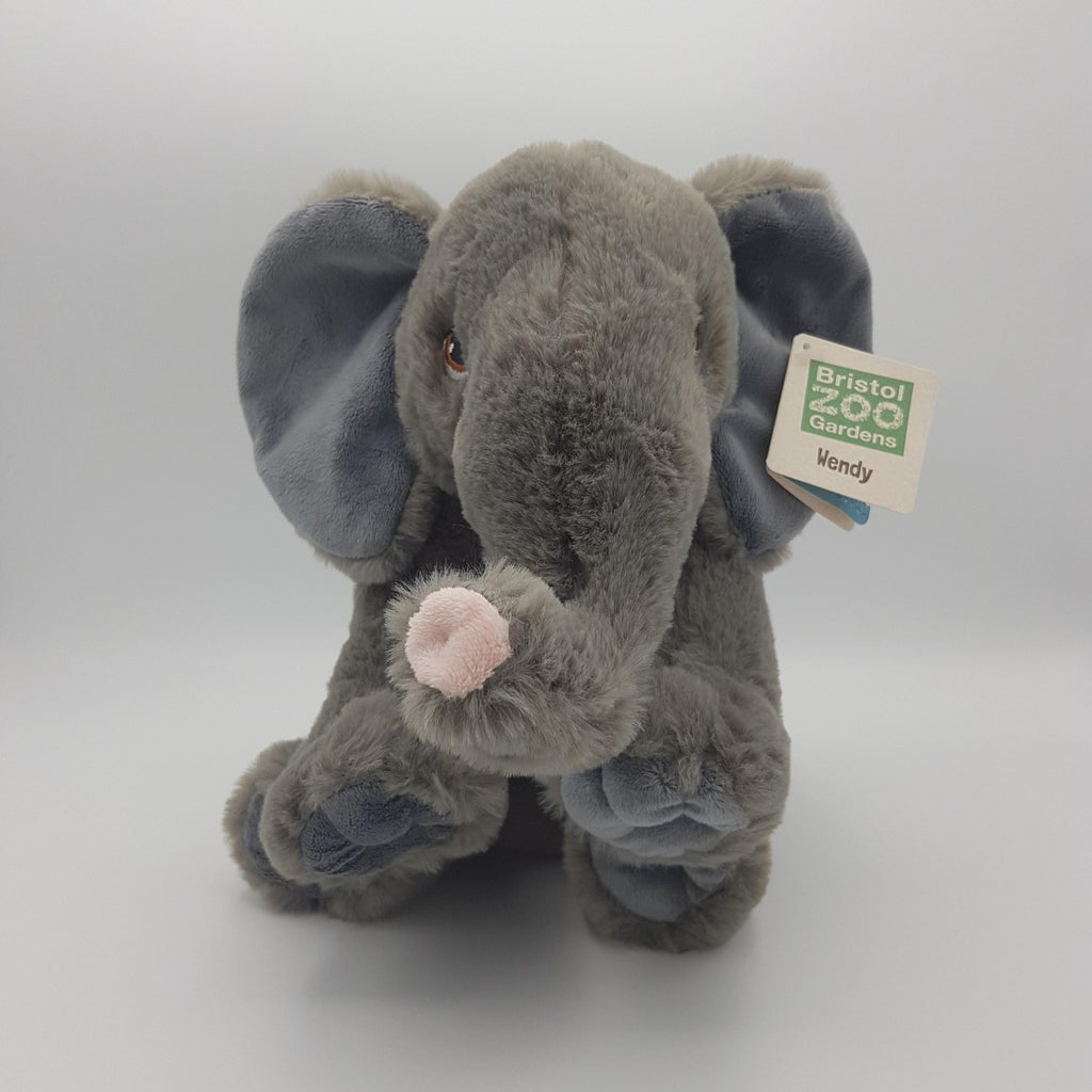 Plush grey elephant toy with tag, sitting upright, front on view