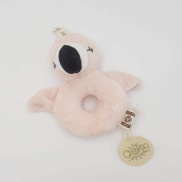 Soft toy rattle. Pink flamingo design with a hole in the centre. Laid flat.