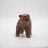 A photo of the toy model of a brown bear from the front