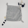 Ring-tailed lemur blanket comforter laid flat. Square blanket with soft grey fur, small arms and black and white tail and head.